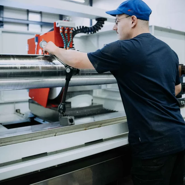 Mitarbeiter bedient eine industrielle Maschine